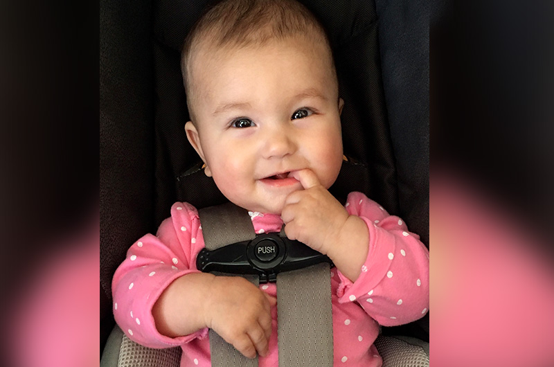 infant girl sitting in a car seat