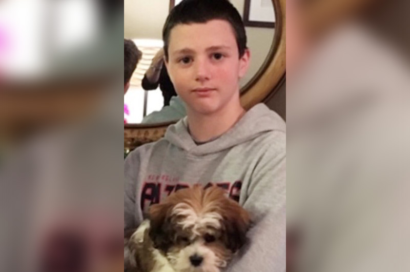 Ryan, who had spinal fusion surgery for scoliosis, holds his puppy Leo.