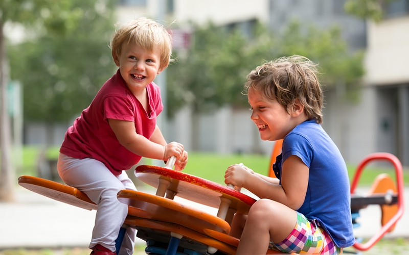playground safety - two little boys playing on a seesaw