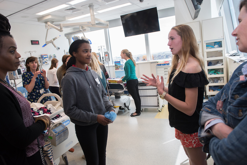 A patient who had spinal fusion surgery talks to another patient and her mother in the simulation lab.