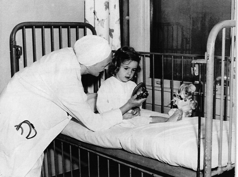 Nurse anesthetist Betty Lank talks with a patient at bedside.