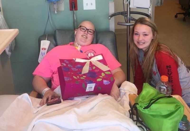 Darcey, who has Li-Fraumeni syndrome, sits with her older sister, Justyna, in the hospital