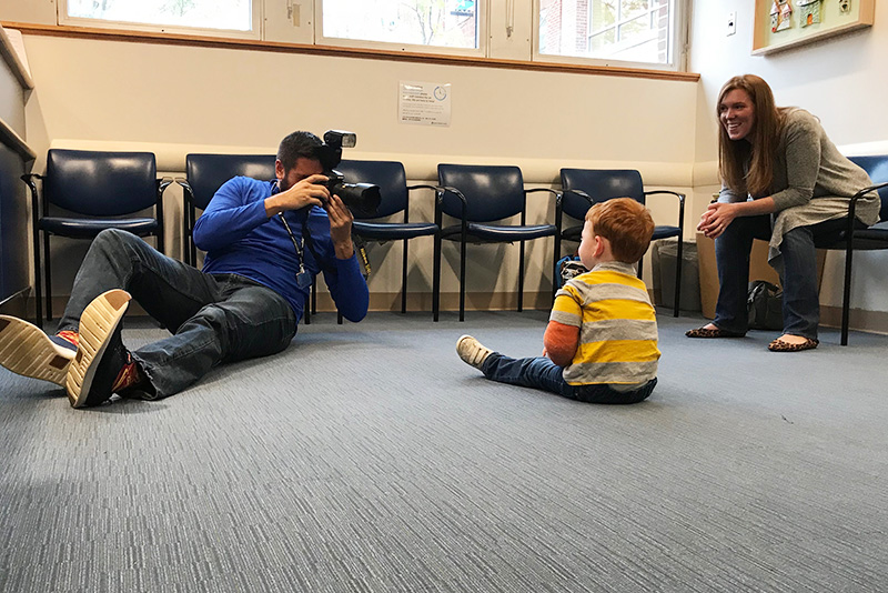 michael goderre lies on floor to take a photo of a patient