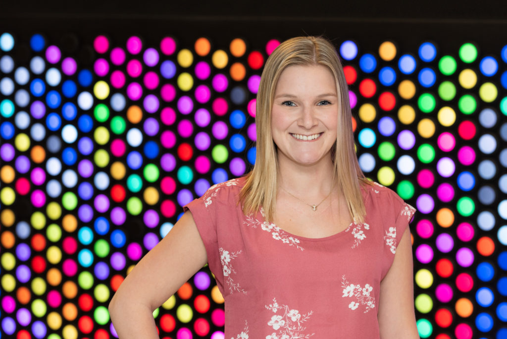 kayla poses in front of colorful wall after meeting with her pain doctor
