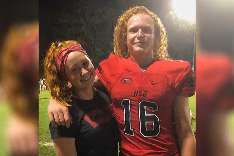 Ryker, who had surgery for osteochondritis dissecans, poses with his sister wearing his New Smyrna Beach football jersey.