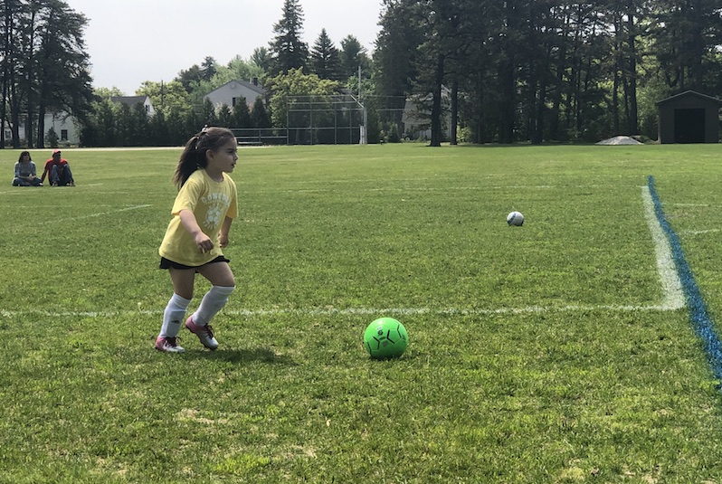 Grace, who had surgery for a cavernous malformation, runs on the soccer field.