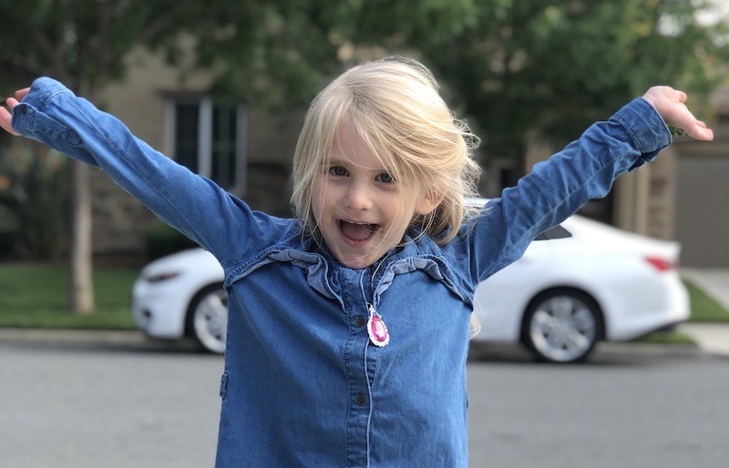Elyse, who had a biventricular repair for heterotaxy, raises her hands in the air