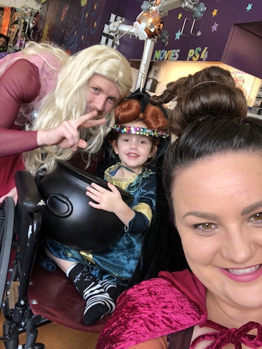 Gracie in costume with her parents for Halloween, several weeks before spinal fusion surgery.