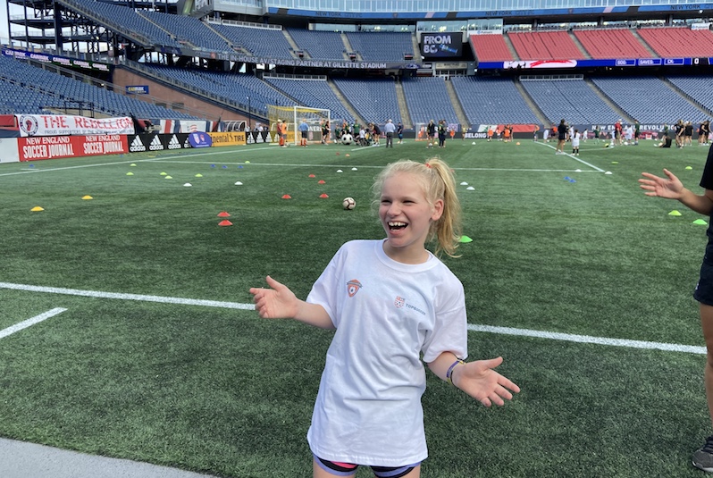 Lily, who has SYNGAP1, on the field at Gillette stadium.