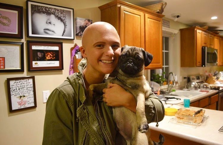 Maddie, who had immunotherapy treatment for cancer, holds her pug.