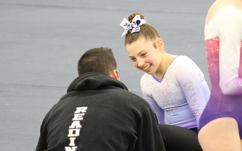 Mikayla, who was treated for hip avulsion fracture, smiles while talking to her coach during a competition.