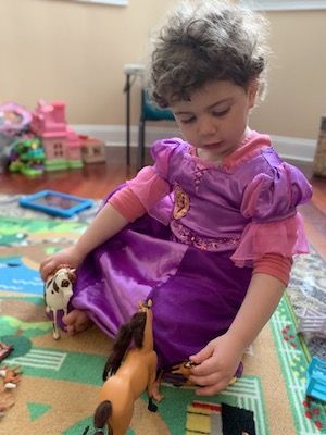Ellery, who has opsoclonus myoclonus syndrome, plays with her horse figurines.