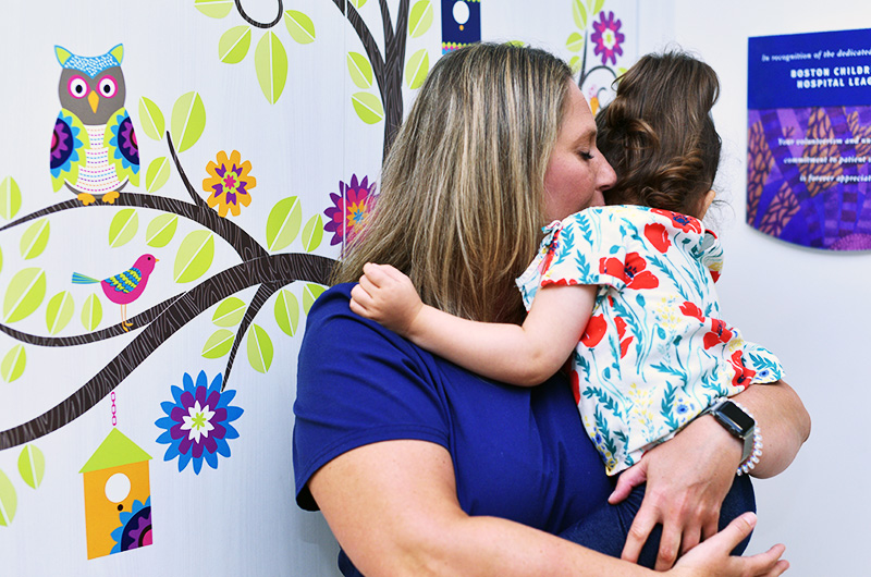 Amelia, who had surgery for epilepsy, gets a hug from her EEG tech