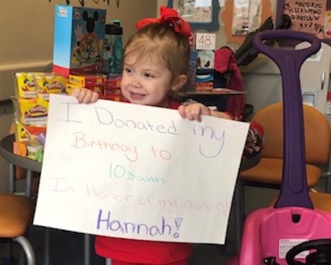Emily, who received a lung transplant, holds a sign thanking her donor.