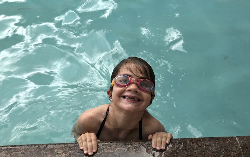 Jane, who had acute flaccid myelitis, having fun at a pool.