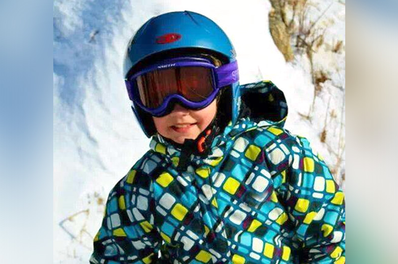 Maria, who was born with congenital scoliosis, out on the slopes in her snowboard suit and helmet.