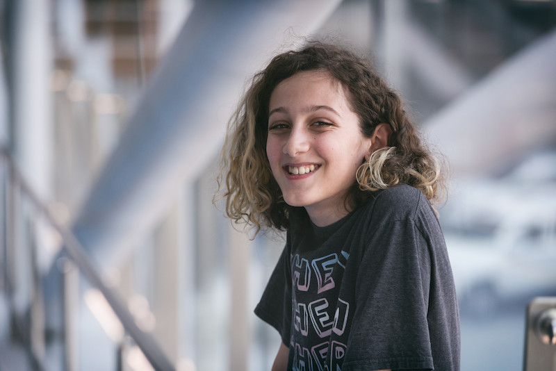 leven, who is non-binary, smiles at the camera