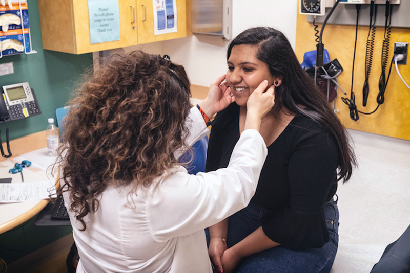 dr cherella checks maya's thyroid at an appointment