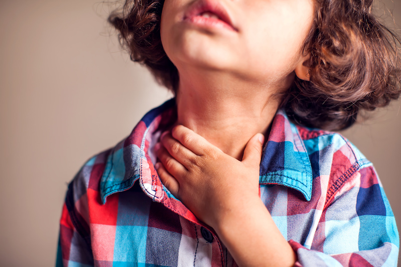 child with motility disorder holding her throat
