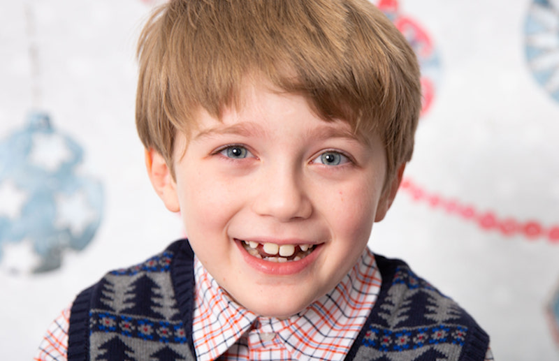 A smiling close-up of Isaac, a young boy who undergoes FMT for c diff illness