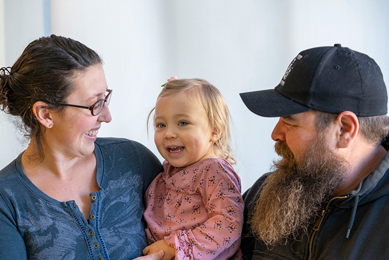 Scarlette, who has PK deficiency, smiles with her parents