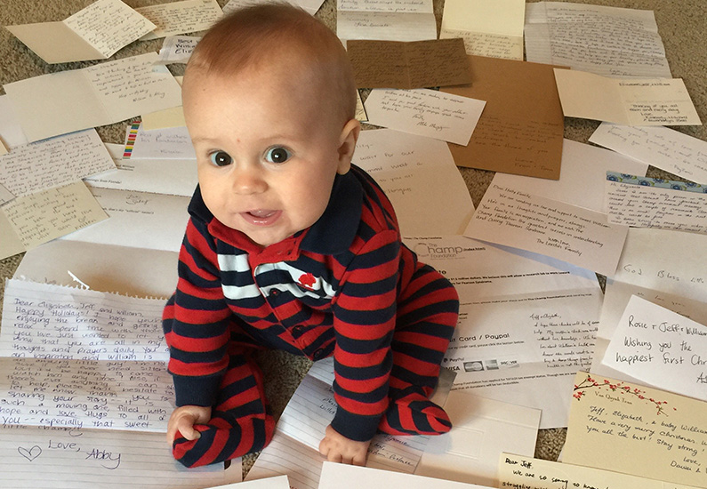 William, who was born with Pearson syndrome, sitting on letters when he was a baby