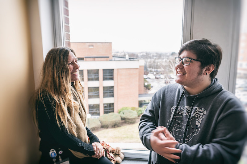 Oliver, a trans teen, chats with his social worker, Ariel Botta.