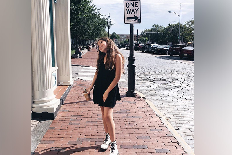 Elijah, a transgender patient, stands on a brick sidewalk in Rhode Island.