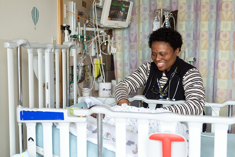 a nurse stands by a patient's crib
