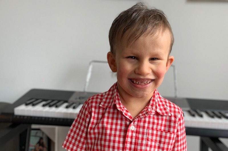 In stands smiling in front of a keyboard.