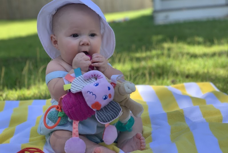 Ruby, who had surgery for truncus arteriosis, chews on a toy in her yard.