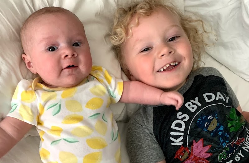 Ruby, who had complex heart surgery, lies on a pillow with her older brother.