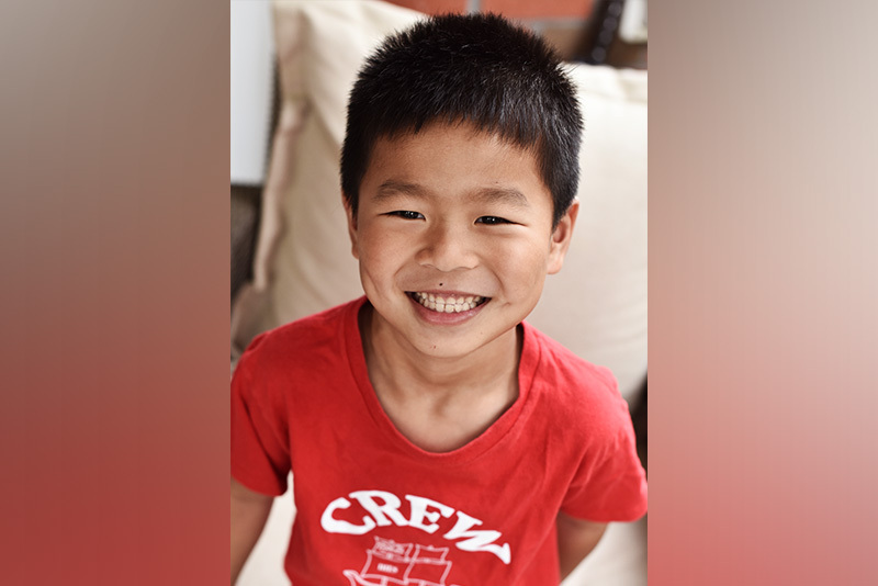 steven, who was born with. an anorectal malformation, smiles and wears a red t-shirt