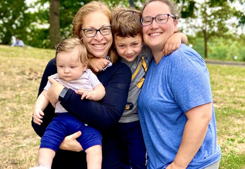 Family photo. Cheryl is holding Gabriel and Ilan has his arms around Sue and Cheryl.