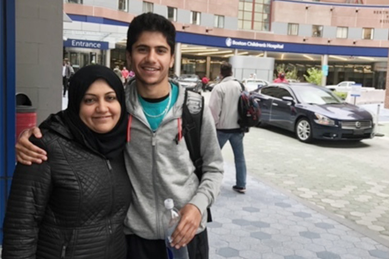 Maythum with his mother standing in front of Boston Children's before a checkup for. midaortic syndrome