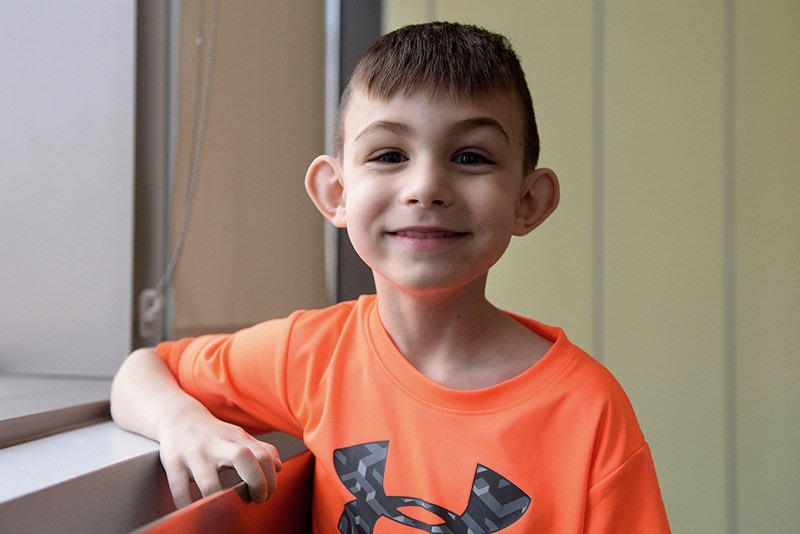 James. who had a stroke, poses in an orange Under Armor shirt