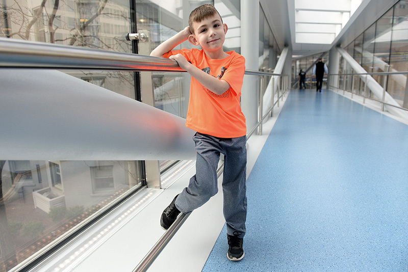 James, who had a stroke, poses on the Boston Children's sky bridge