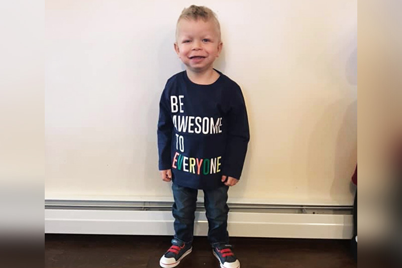 Rylan, who has a laryngeal cleft, wears a shirt that reads, "be awesome to everyone."