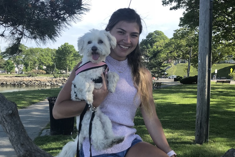 Carolann, who had surgery for her ear after several falls and concussions, holds her small Maltese dog.