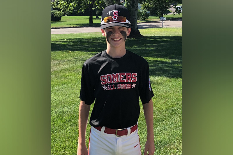 Brendan, who had distended bladder and hydronephrosis, in his "Somers All Stars" baseball uniform. He is smiling.