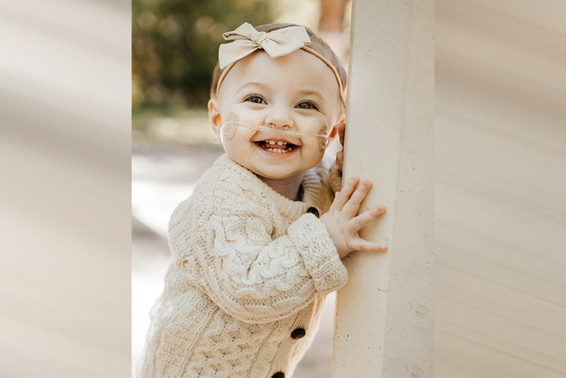 Scarlett smiles at the camera. She is wearing a white sweater.