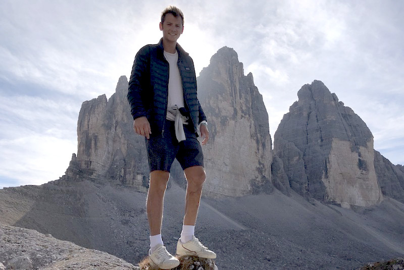 Michael, who had osteosarcoma, poses in front of rocky cliffs