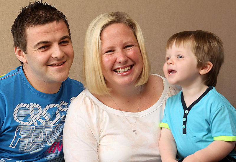 Matthew, who was born with ALD, poses with his parents